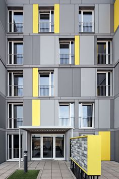 an apartment building with several balconies and yellow shutters