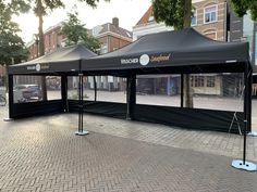 a large black tent on the side of a street