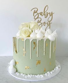 a baby boy cake decorated with white flowers and icing