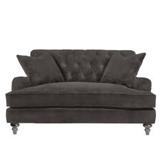 a black velvet couch with two pillows on it's back and one arm extended