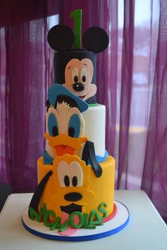 a mickey mouse birthday cake with goofy and donald on top