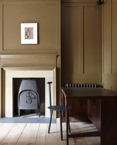 a room with a chair, fireplace and pictures on the wall