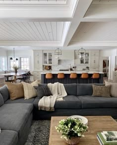 a living room filled with furniture next to a kitchen