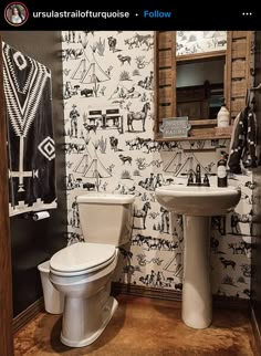 a bathroom with a toilet, sink and wallpaper in black and white color scheme