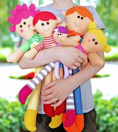 a woman holding several stuffed dolls in her arms