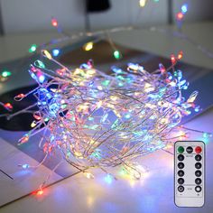 a close up of a christmas light on a table with a remote control next to it