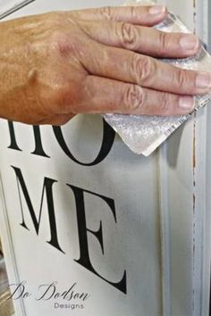 a person's hand wiping down the front door with a cloth on top of it