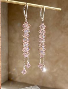 Pink Crystal Chandelier Statement Earrings DESCRIPTION These earrings feature top quality genuine Swarovski crystals that are hand-woven with Silver wire and suspended from the same quality 925 Sterling Silver lever backs. The feature show stopping sparkle with elongated slender design finished with tiered dangled crystals dripping off the end. These are also highly versatile as they can be styled either as bridal, cocktail attire, or just to add a glamorous pop to your casual everyday-wear.  DE Elegant Faceted Beaded Drop Earrings, Single Long Drop Crystal Earring, Crystal Dangle Chandelier Earrings, Crystal Dangle Chandelier Earrings For Pierced Ears, Crystal Long Drop Chandelier Earrings As Gift, Crystal Dangle Earrings With Ear Wire, Faceted Crystal Dangle Earrings, Crystal Long Drop Jewelry With Matching Earrings, Formal Faceted Dangle Crystal Earrings