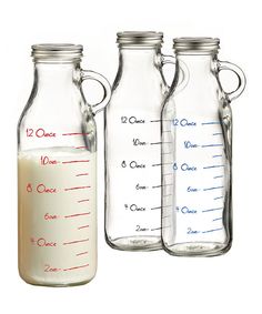 three glass jugs filled with milk are shown in front of the same measuring cup