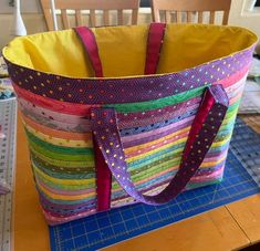 a large colorful bag sitting on top of a table next to a pair of scissors