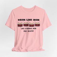 Celebrate the special moms who support their drummers with our exclusive "Drumline Mom - Like a Normal Mom But Deafer" t-shirt. This fun and witty shirt is perfect for any proud drumline mom who stands by her child at every rehearsal and performance, despite the noise! Made from high-quality Bella Canvas fabric, this unisex tee offers comfort and style for everyday wear. This classic unisex jersey short sleeve tee fits like a well-loved favorite. Soft cotton and quality print make users fall in Music-themed Slogan Tops For Concerts, Music-themed Cotton Top With Text Print, Music-themed Short Sleeve Tops With Text Print, Music-themed Slogan Crew Neck Top, Music-themed Slogan Top With Crew Neck, Music-themed Slogan Tops With Crew Neck, Music-themed Tops With Text Print And Short Sleeves, Music-themed Text Print Short Sleeve Tops, Music-themed Cotton Tops With Slogan