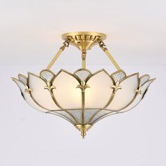 a semi flush ceiling light with white glass shades and gold trimmings on the bottom