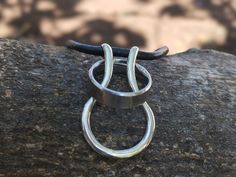 This silver and leather ring holder necklace is a great way for you to keep your ring safe while at work or doing other tasks where wearing a ring can be dangerous. It is made with sterling silver hand formed into a pendant onto which you can slip your ring. We have used a real leather thong to make the necklace - it is 55 cm long but you can let us know what length you prefer. Necklace Ring Holder Men, Modern Adjustable Jewelry With Soldered Detail, Michelle Baker, Ring Halter, Ring Holder Necklace, Leather Ring, Le Port, Mens Ring, Men's Ring