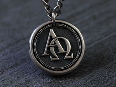 Fusing elegance and profound symbolism, our handcrafted Titanium Alpha Omega necklace is crafted with meticulous attention to detail and features a custom message of your choice on the backside of pendant. The Alpha Omega holds deep significance, representing faith in God's eternal presence and the belief in Christ as the source of salvation and fulfillment. Our 3D rendition of the Alpha Omega serves as a tangible symbol of unwavering faith and devotion. Perfect accessory for those who appreciate fine craftsmanship and symbolism. Elevate your style while affirming your faith with our handsome Titanium Alpha Omega Necklace. FRONT Engraving (raised engraving) This necklace features the Greek letters Alpha (Α) and Omega (Ω), symbolizing the eternal nature of God as the beginning and the end, Luxury Silver Jewelry With Engraved Logo, Elegant Silver Jewelry With Engraved Logo, Customizable Silver Necklaces, Luxury Engraved Logo Jewelry For Gift, Silver Jewelry With Engraved Logo, Luxury Silver Necklace With Engraving Option, Silver Round Jewelry With Engraved Logo, Elegant Jewelry With Engraved Logo For Gift, Silver Jewelry With Engraved Logo For Gift