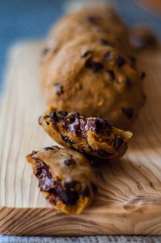 chocolate chip muffins on a wooden cutting board with a bite taken out of one