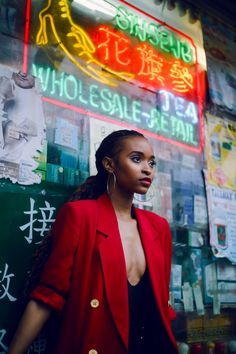 a woman standing in front of a neon sign