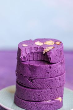 a stack of purple cake sitting on top of a white plate