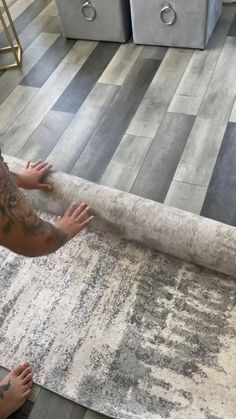 a man laying on top of a rug in a living room