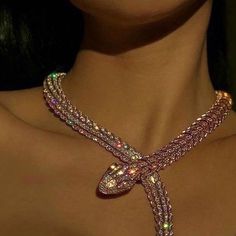 a close up of a woman's neck wearing a necklace with an intricate design