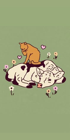 two cows laying on top of each other with a cat sitting on the cow's back