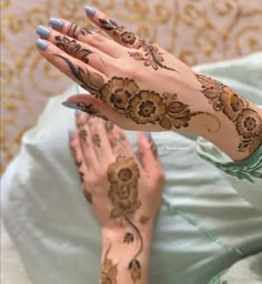 two hands with henna tattoos on them