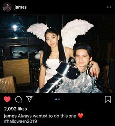 a man and woman dressed up in costumes posing for a photo with angel wings on their shoulders