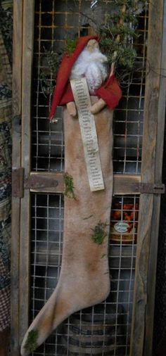 a christmas stocking hanging on the side of a wooden fence with an old scroll