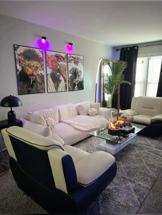 a living room with two couches, a coffee table and pictures on the wall