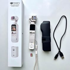 an electronic device with two cameras attached to it next to a charger and power cord