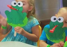 two children with paper puppets in front of them