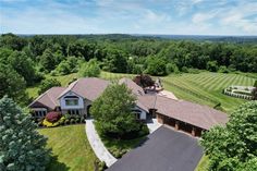 an aerial view of a large home surrounded by trees