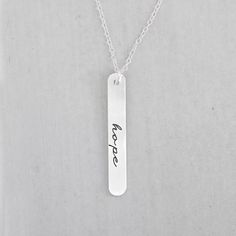 "A cute hand stamped \"hope\" necklace. This is a personalized necklace hand stamped with the phrase \"hope\". The sterling silver bar measures 25mm in length. Without any special requests, this necklace will be sent stamped with \"hope\" but alternatively, it can be personalized upon request. The bar holds up to 10 characters maximum [including spaces]. The bar pendant hangs from an 18\" sterling silver chain. Each necklace is custom made to order. Please feel free to send a message if you have Air Jordan 1 Court Purple, Hope Necklace, Inspirational Jewelry, Perfect Wedding Gift, Silver Bar, Bar Pendant, Silver Bars, Personalized Necklace, Sterling Silver Chain