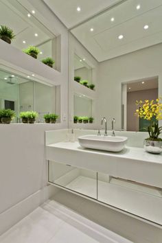 a white bathroom with plants in the sink and mirrors on the wall above it that says instagram deoccasabela