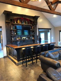 a living room filled with furniture and a flat screen tv mounted to the wall above a bar