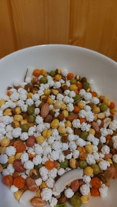 a white bowl filled with corn and nuts