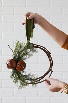 a person holding a wreath with leaves and acorns