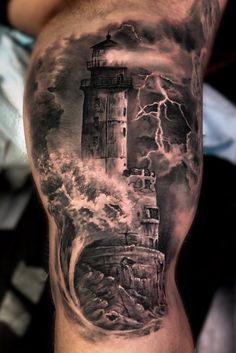 a man's arm with a lighthouse and storm coming in from the ocean on it