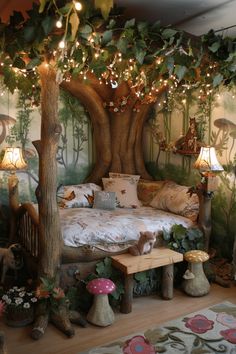 a room with a bed, tree and lights on the ceiling is decorated in woodland theme