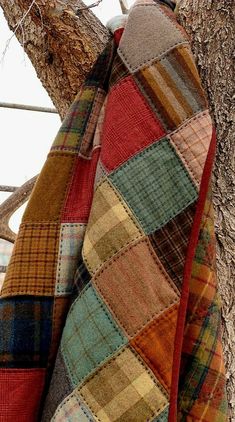 a plaid coat hanging on a tree branch