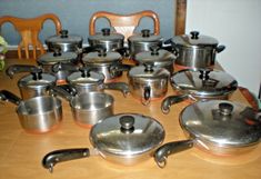 a wooden table topped with pots and pans