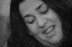 a black and white photo of a woman with her eyes closed while she is smiling