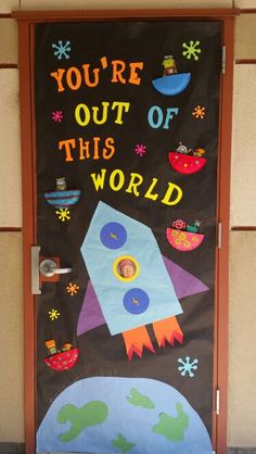 a door decorated with the words you're out of this world and an image of a rocket ship