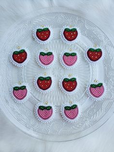 a white plate topped with red and green strawberries on top of a white table