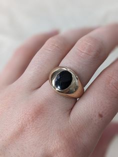 This chunky signet ring is so fun and bold, but still casual enough for every day wear. It is hefty and domed with an oval black onyx inlay. Crafted in 10k yellow gold this piece weighs 7.59 grams. It is currently a US size 7.25 but could be sized slightly up or down by your local jeweler. It is in great vintage condition with minimal light wear to the surface of the metal but no dents or dings. Everyday Black Signet Ring With Polished Finish, Classic Oval Black Enamel Signet Ring, Modern Black Oval Signet Ring, Black Vintage Jewelry For Everyday, Vintage Black Jewelry For Everyday, Black Vintage Everyday Jewelry, Vintage Black Signet Ring With Polished Finish, Vintage Oval Signet Ring For Everyday, Everyday Vintage Oval Signet Ring