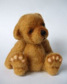 a brown teddy bear sitting up against a white background