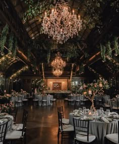 an indoor wedding venue with chandeliers and tables