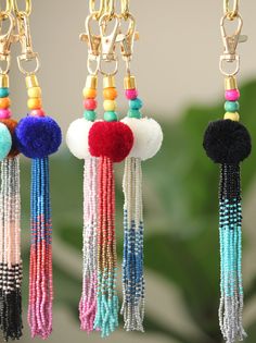 four different colored beads hanging from chains