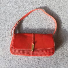 an orange purse laying on the floor