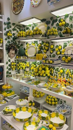 there are many plates and bowls on display in the store with lemons all over them