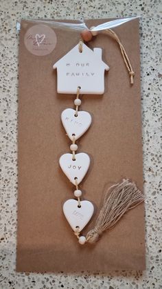 a card with hearts and a house hanging from it's side on a table